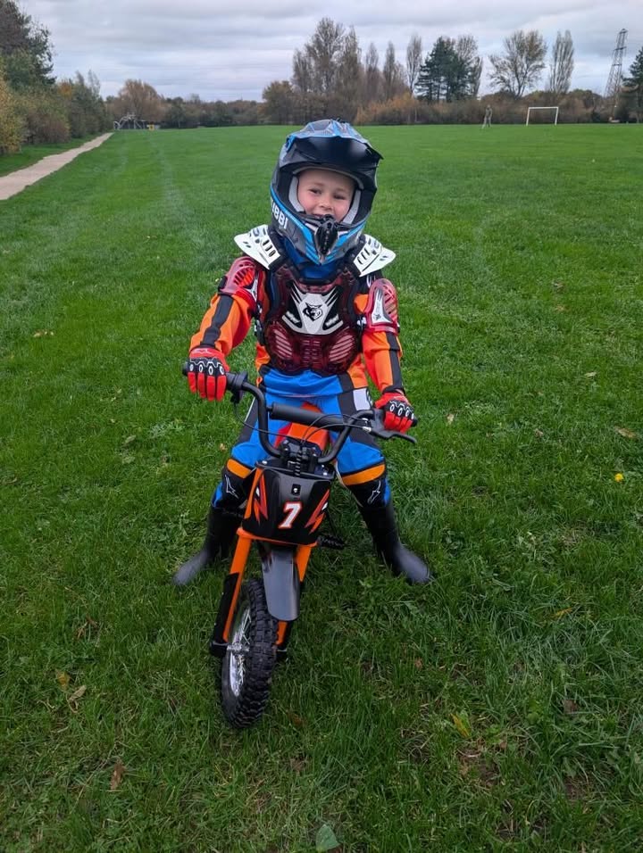 Child wearing a helmet riding a Kubbi electric dirt bike safely