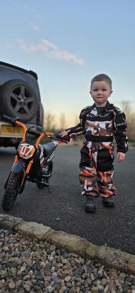 Kid riding a Kubbi electric dirt bike outdoors