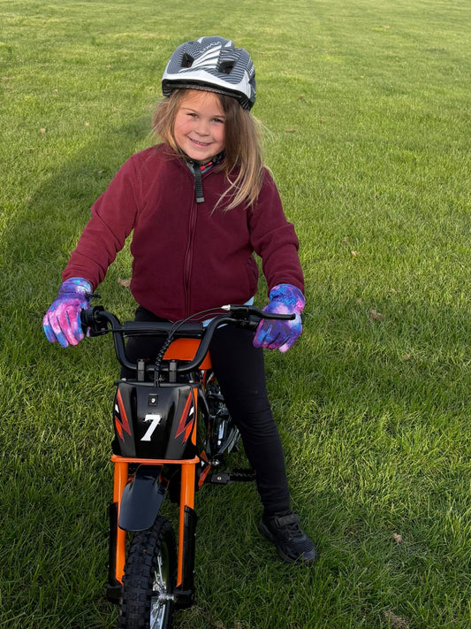 Boy aged 6-12 riding a Kubbi electric dirt bike as a birthday gift