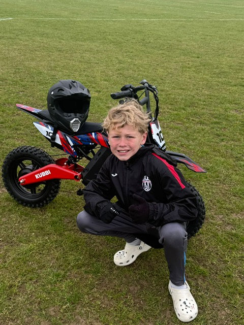 Kubbi electric dirt bike for kids being ridden off-road