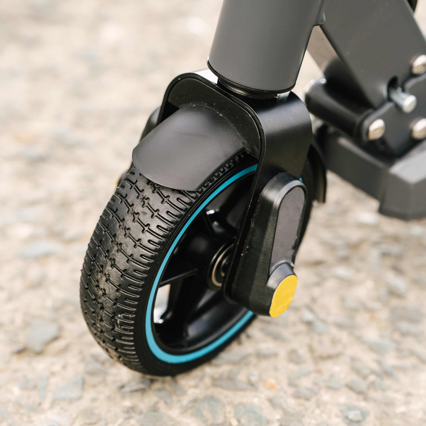 Close-up of the Kubbi S9 Pro electric scooter front wheel with durable tire and sturdy suspension system on pavement surface