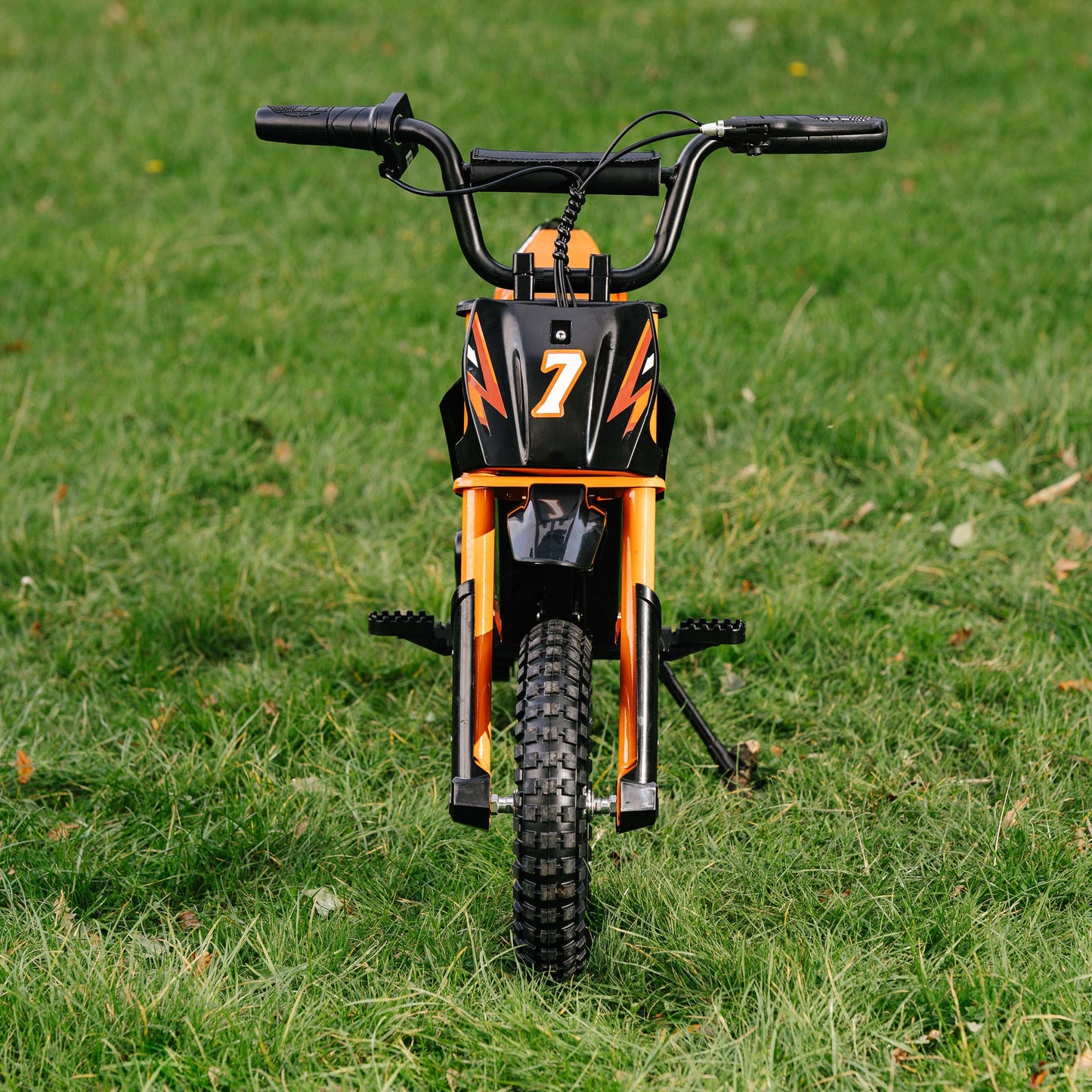 Front view of Kubbi K7 Pro Dirt Bike for kids on grass with black and orange design